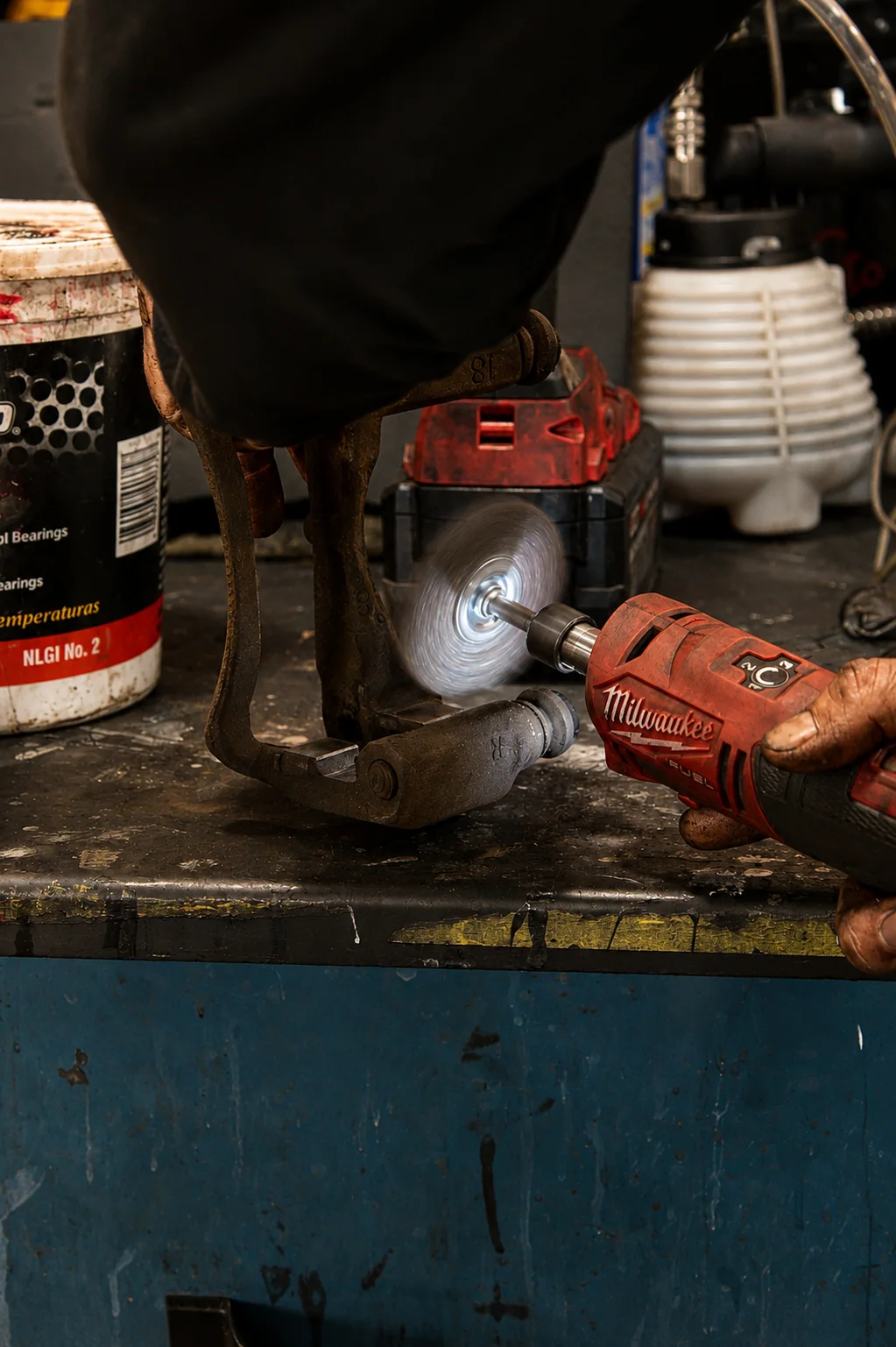 Brake caliper bracket being cleaned by a technician