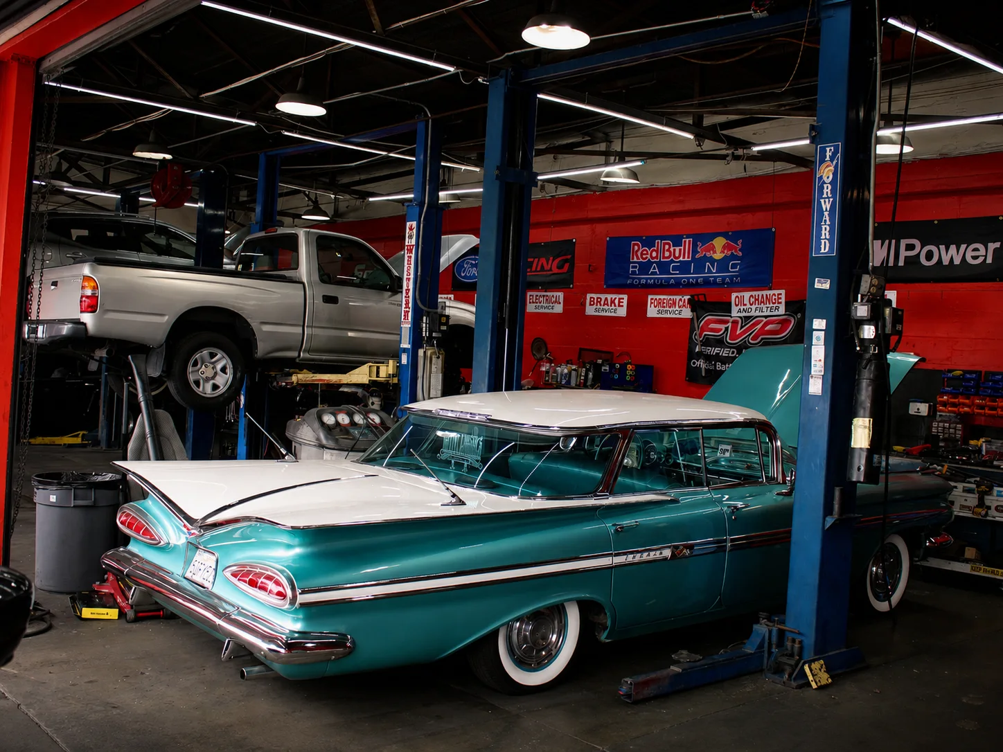 Classic Impala and modern truck inside Alex Jr’s Long Beach auto repair shop