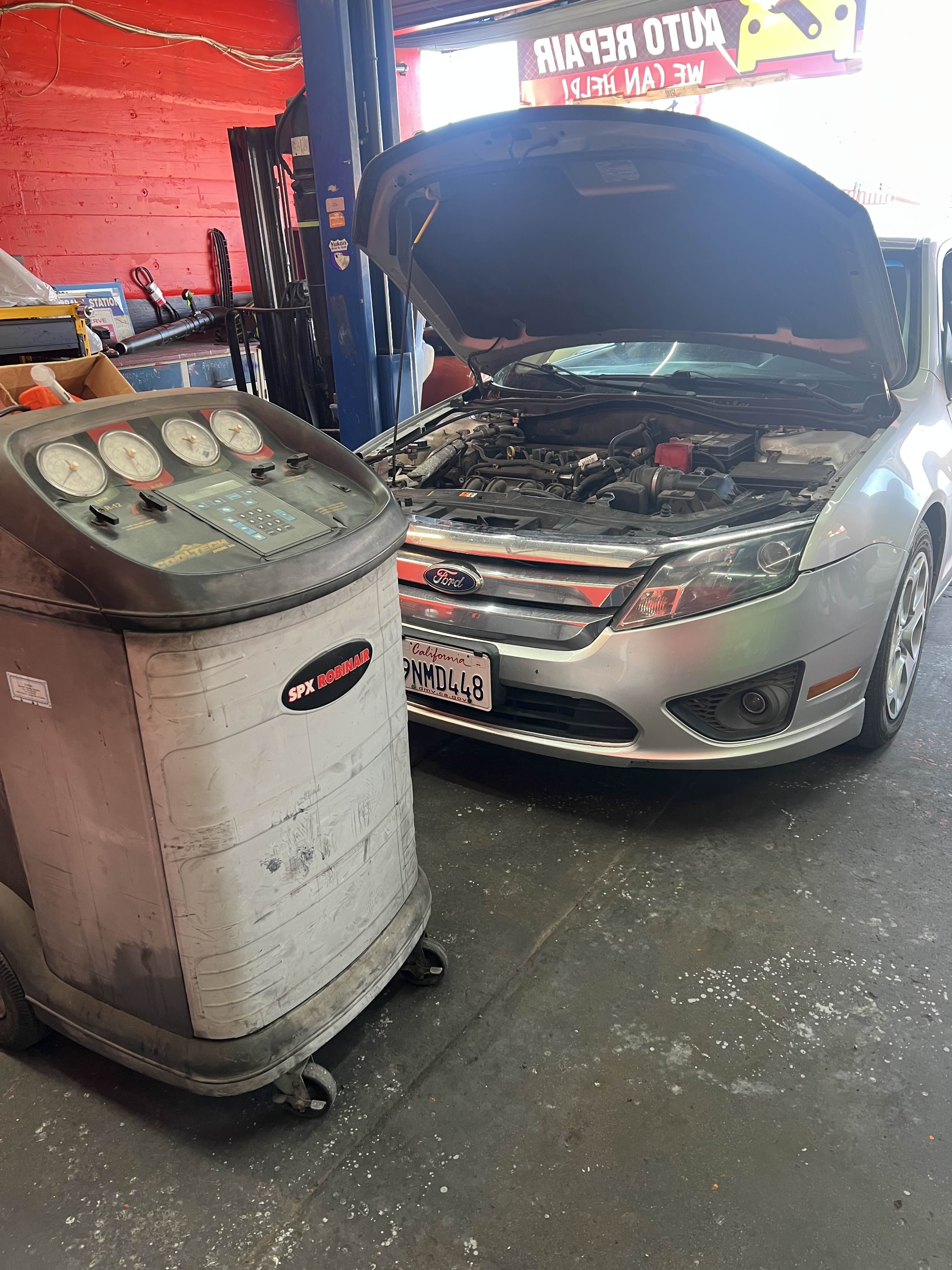 A/C service machine connected to a Ford sedan